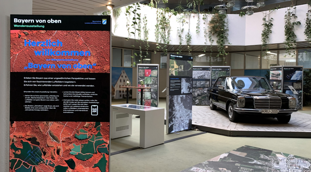 Wanderausstellung  Blick in den Ausstellungsraum, das Krumbacher Rathaus-Foyer. Links eine Ausstellungstafel, rechts eine schwarze Limousine, die dauerhaft im Rathaus-Foyer steht.